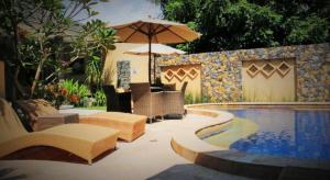 piscina con sedie e ombrellone di Matahari Inn a Gili Trawangan
