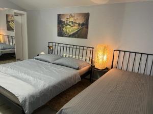 a bedroom with two beds and a lamp and a painting at Apartments RENESANCE in Bojnice