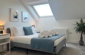 a bedroom with a bed and a skylight at Stunning Town Centre Penthouse w/ Sea Views in Penzance