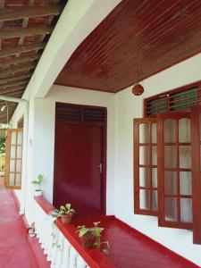 una puerta roja de una casa con plantas en ella en Villa Samudra Hikkaduwa en Hikkaduwa