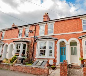 a red brick house with a blue door at Exquisite renovation in central location in Hereford