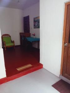 a living room with a table and a green chair at Villa Samudra Hikkaduwa in Hikkaduwa