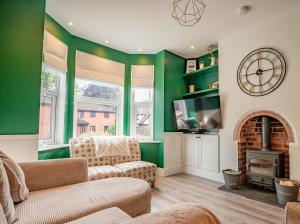 a living room with green walls and a fireplace at Exquisite renovation in central location in Hereford