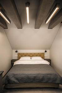 a bedroom with a large bed in a attic at Senamiesčio apartamentai in Anykščiai