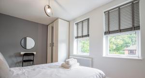 ヘレフォードにあるExquisite Renovation in Central Location with Garden and Parkingの白いベッドルーム(ベッド1台、窓2つ付) +28枚の写真