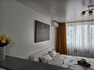 - une chambre avec un lit, une table et une fenêtre dans l'établissement Vio's Galati Apartment, à Galaţi