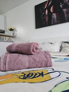 a pile of towels sitting on top of a bed at Vio's Galati Apartment in Galaţi
