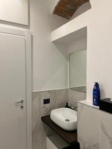 Baño blanco con lavabo y espejo en Luxury apartment Navigli, en Milán