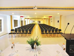 an empty hall with chairs and a podium in a room at Hotel Hills Park in Pathanāmthitta