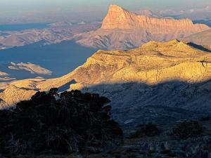 a view of a mountain with the sun shining on it at Atiaf Jabal Shams house in Misfāh