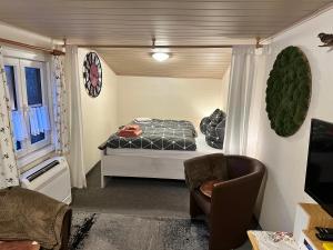 - une petite chambre avec un lit et une chaise dans l'établissement Blockhäusl am Jonsberg, à Jonsdorf