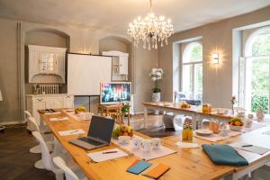 a kitchen with a large wooden table with a laptop on it at Schloss Blankensee exklusiv in Trebbin