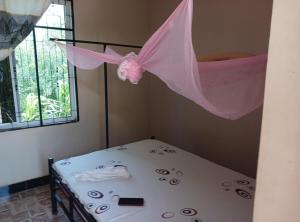 Habitación con cama con mosquitera rosa en Mombo Maasai Culture Homestay, 