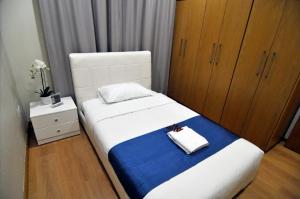 1 dormitorio con 1 cama grande con manta azul y blanca en 11 Suites - Sunrise Horizon Suite en Lárnaca