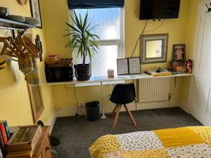 a bedroom with a bed and a desk with a plant at Double Room in Newhaven with own TV & Microwave -plus cereal and toast breakfast in Tarring Neville