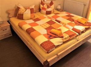 a bed with a checkered blanket and pillows on it at Pension 'Am Vogelherd' in Schleiz