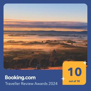 una señal amarilla que dice premios de revisión de viajes con una foto de un campo nublado en Agradable y cómoda cabaña con vista espectacular en Chonchi