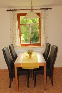 stół jadalny z czarnymi krzesłami i oknem w obiekcie Pension 'Am Vogelherd' w mieście Schleiz
