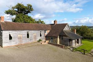 an old white building with a roof at Spacious Holiday Cottage with Scenic Views in Church Stretton +7 photos