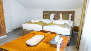 a room with two beds and a wooden table with a tableasteryasteryasteryastery at E&B Apartments Waiblingen bei Stuttgart in Waiblingen +5 photos