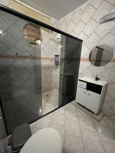 a bathroom with a shower with a toilet and a sink at Pousada Recanto dos Sonhos in Alto Paraíso de Goiás