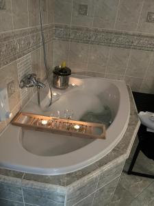 a bath tub with candles and wine glasses in it at Apartments RENESANCE in Bojnice