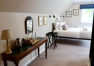 a bedroom with a bed and a table with a mirror at Tigh an Truish Inn in Oban