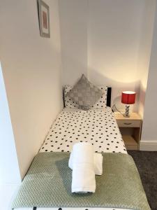 a bedroom with a bed with a pile of towels on it at Beautiful Mordern Apartment with Bathroom in Seacombe