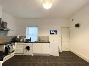 eine Küche mit Spüle, Waschmaschine und Trockner in der Unterkunft Beautiful Mordern Apartment with Bathroom in Seacombe
