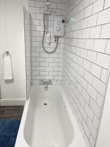 a white bathroom with a bath tub in it at Beautiful Mordern Apartment with Bathroom in Seacombe