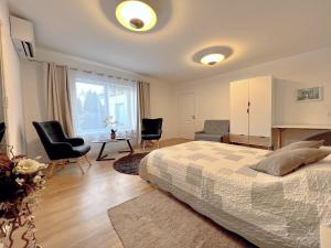 1 dormitorio con 1 cama, 2 sillas y escritorio en Amphora en Ventspils