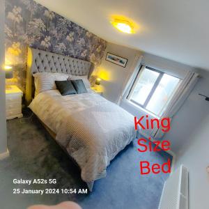 a bedroom with a king size bed and a window at Mews Apartment Main St, Carrigart, F92HC04 in Carrigart