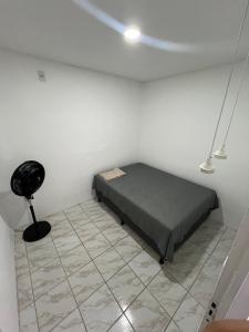 1 dormitorio con 1 cama en una habitación blanca en Nox Temporada - Casa com Piscina e Churrasqueira, en Caruaru