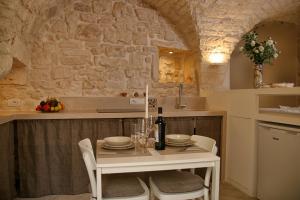 une cuisine avec une table avec une bouteille de vin dans l'établissement DeaDomus 55, à Cisternino