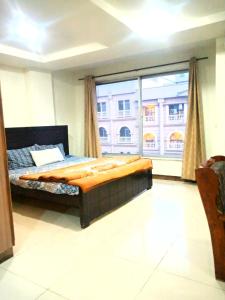 een slaapkamer met een bed en een groot raam bij Comfortable Rental Apartments In Bahria Town in Rawalpindi