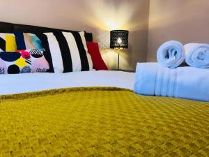 una camera da letto con un grande letto con una coperta gialla di Lux Home Stays - Regents Place a Leamington Spa