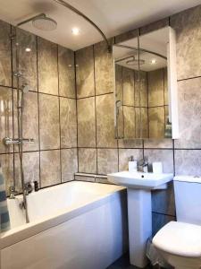 een badkamer met een bad, een wastafel en een toilet bij Lux Home Stays - Regents Place in Leamington Spa