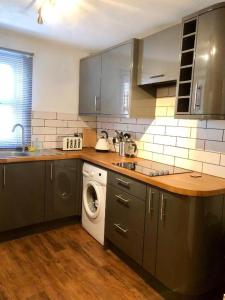 een keuken met een wasmachine en een vaatwasser bij Lux Home Stays - Regents Place in Leamington Spa