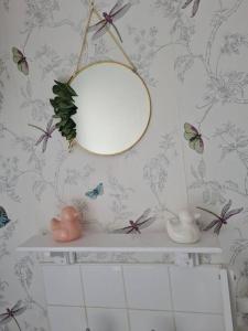 a bathroom with a mirror and a shelf with butterflies at Cosy home in Stornoway