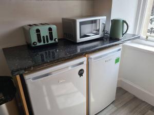 Um micro-ondas e uma torradeira num balcão de cozinha em Cosy home em Stornoway