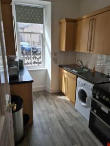 a kitchen with a washing machine and a window at Cosy home in Stornoway