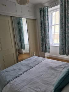 a bedroom with a large bed and a window at Cosy home in Stornoway