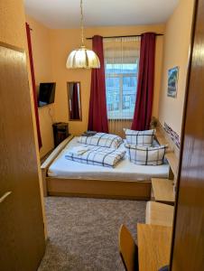 a bedroom with a bed with pillows and a window at Bahnhotel Dippoldiswalde in Dippoldiswalde