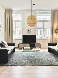 - un salon avec deux canapés et une télévision à écran plat dans l'établissement MAKERS + ROOMS APARTMENTS, à Detmold