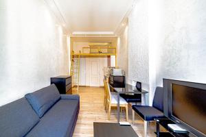 a living room with a couch and a table and a television at Le petit ANNA 4 pers in Villeurbanne