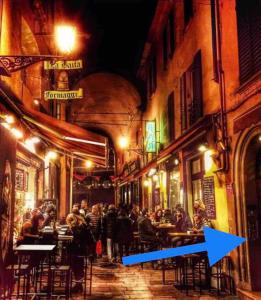 a group of people sitting at tables in a street at night at Appartamento Pescherie - Top location in Bologna