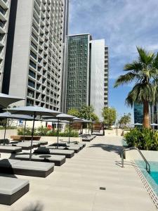 een rij tafels en stoelen met parasols voor de gebouwen bij Stunning Studio in Business Bay in Dubai