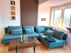 a living room with a blue couch and a table at Nordic style apartment in central Aalborg with a beautiful city view in Aalborg