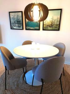 uma sala de reuniões com uma mesa branca e cadeiras em Nordic style apartment in central Aalborg with a beautiful city view em Aalborg