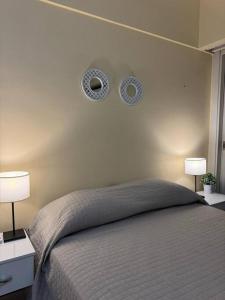 een slaapkamer met een bed met twee lampjes aan de muur bij Apartamento Torre Costanera 2 Bitcoins House in Corrientes